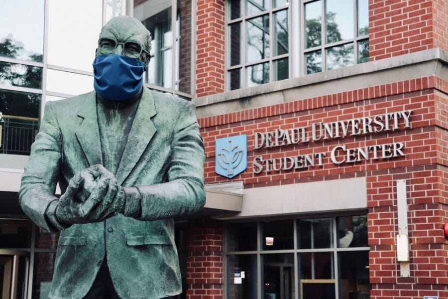 The statue of John J. Egan, located outside of the Lincoln Park Student Center, wearing a mask.