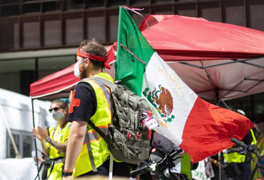Un hombre que forma parte del personal de primeros auxilios alza la bandera de México. 
