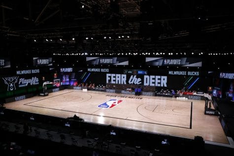Referees huddle on an empty court at game time of a scheduled game between the Milwaukee Bucks and the Orlando Magic for Game 5 of an NBA basketball first-round playoff series, Wednesday, Aug. 26, 2020, in Lake Buena Vista, Fla.