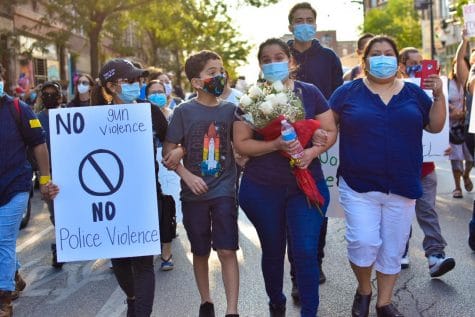 La madre de Miguel, María Vega, llevó un ramo de rosas blancas mientras la familia marchaba. // Miguel's mother, Maria Vega, carries a bouquet of white rosas while the family leads the march.