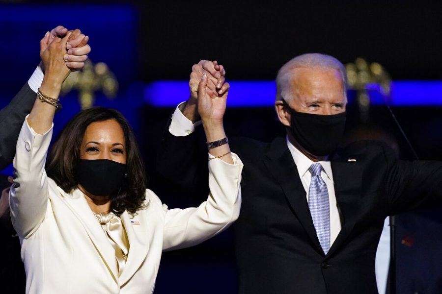 FILE - In this Nov. 7, 2020, file photo Vice President-elect Kamala Harris holds hands with President-elect Joe Biden and her husband Doug Emhoff as they celebrate in Wilmington, Del. Black policy leaders will play a pivotal role in President-elect Joe Biden’s transition team, marking one of the most diverse presidential agency review teams in history. (AP Photo/Andrew Harnik, File)
