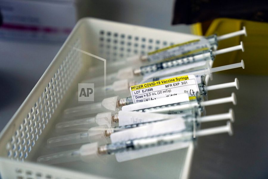 FILE - In this Jan. 7, 2021, file photo syringes containing the Pfizer-BioNTech COVID-19 vaccine sit in a tray in a vaccination room at St. Joseph Hospital in Orange, Calif. Taking a new direction to speed release of coronavirus vaccines, President-elect Joe Bidens office said Friday he would end the current practice of holding back vaccine doses to guarantee that people who get their first shot can also get a required second inoculation three weeks later. (AP Photo/Jae C. Hong, File)