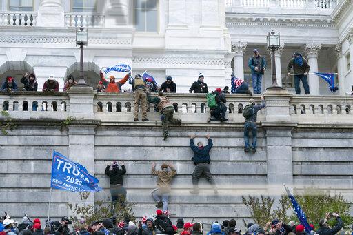 Supporters of President Donald Trump climb the west wall of the the U.S. Capitol on Wednesday, Jan. 6, 2021, in Washington. (AP Photo/Jose Luis Magana)