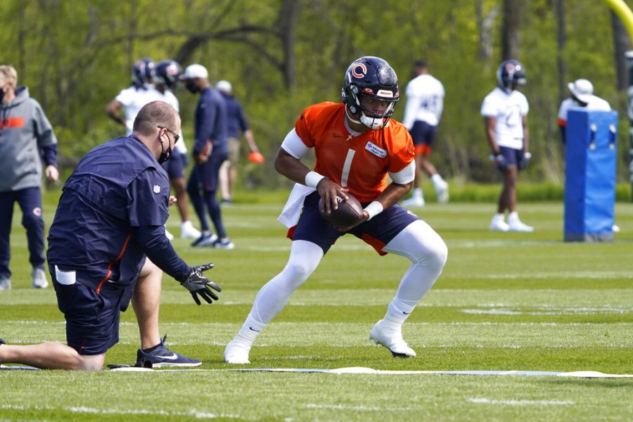 Chicago Bears quarterback Justin Fields (1) looks to hand off the ball during the NFL football teams rookie minicamp Friday, May, 14, 2021, in Lake Forest Ill. (AP Photo/David Banks, Pool)