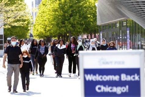 People walk along Chicago's Navy Pier, Friday, May 14, 2021. The U.S. Centers for Disease Control and Prevention eased its guidelines, saying fully vaccinated people can resume activities without wearing masks. (AP Photo/Shafkat Anowar)