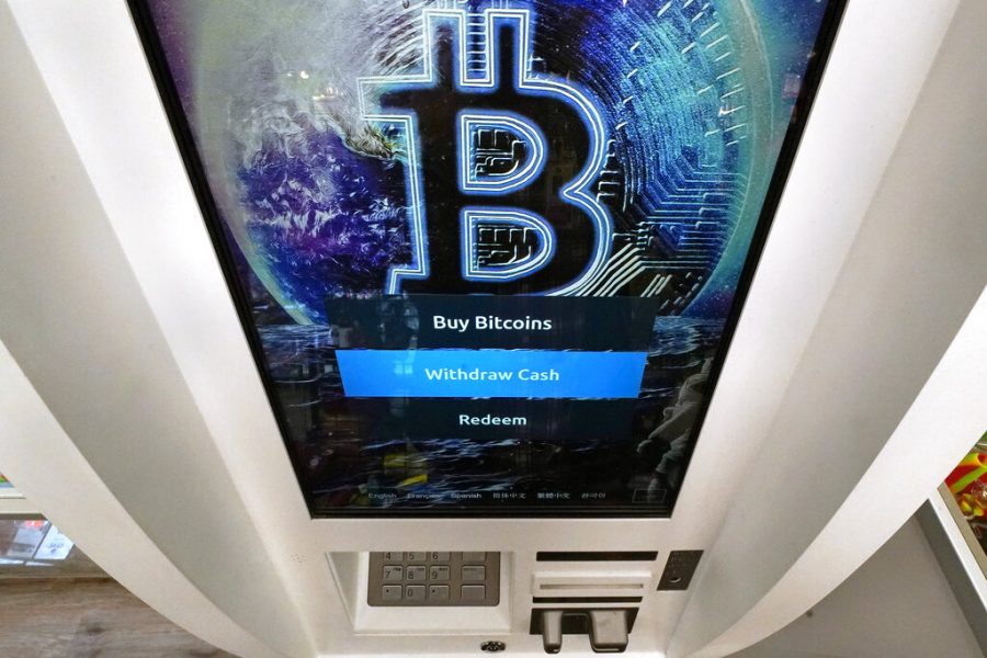 FILE - In this Feb. 9, 2021 file photo, the Bitcoin logo appears on the display screen of a crypto currency ATM at the Smokers Choice store in Salem, N.H.  The price of Bitcoin fell as much as 29% Wednesday, May 19 after the China Banking Association warned members of risks associated with digital currencies. Other digital currencies suffered sharp declines as well.  (AP Photo/Charles Krupa, File)