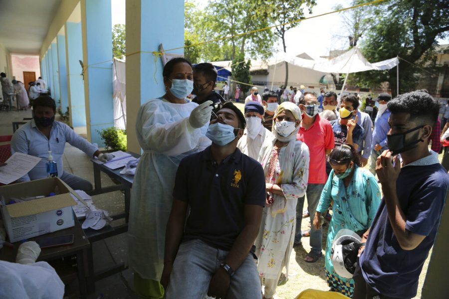 People line up to get tested for COVID-19 in Jammu, India, Monday, May 24, 2021. India crossed another grim milestone Monday of more than 300,000 people lost to the coronavirus as a devastating surge of infections appeared to be easing in big cities but was swamping the poorer countryside. (AP Photo/Channi Anand)