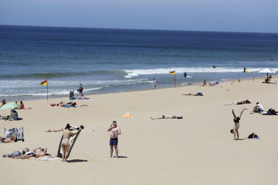 People sunbathe at Carcavelos beach near Cascais, outside Lisbon, Friday, June 4, 2021. Britain said Thursday that it is removing Portugal from its list of COVID-safe travel destinations, meaning thousands of U.K. residents currently on vacation there face the prospect of 10 days quarantine on return.