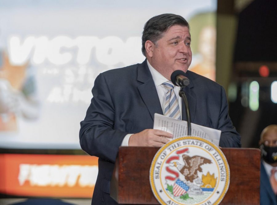Governor J.B. Pritzker speaks at State Farm Center on the University of Illinois campus in Urbana on Tuesday, June 29, 2021. He spoke before signing a bill that allows college athletes in the state to profit off of their name, image, and likeness. (Anthony Zilis/The News-Gazette via AP)