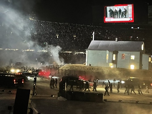 The set of Kanye West's "Donda" listening event, which features a replica of the artist's childhood home and various people in all-black clothing. (Courtesy of Stafford Hipp)