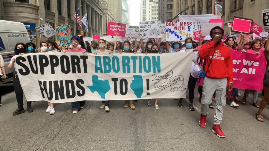 Los manifestantes marchan en Clark Street para protestar los derechos reproductivos.
