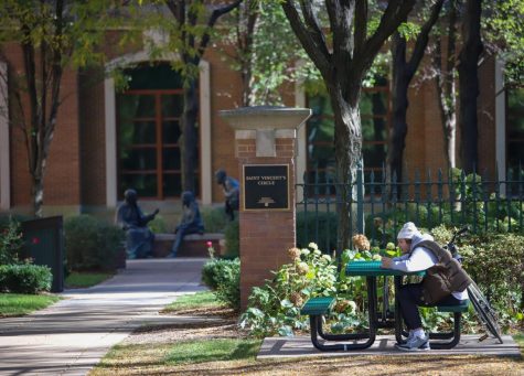 A student sits at Saint Vincent’s Circle in DePaul’s Lincoln Park campus. Students have returned to campus after a full year of online classes due to Covid-19.