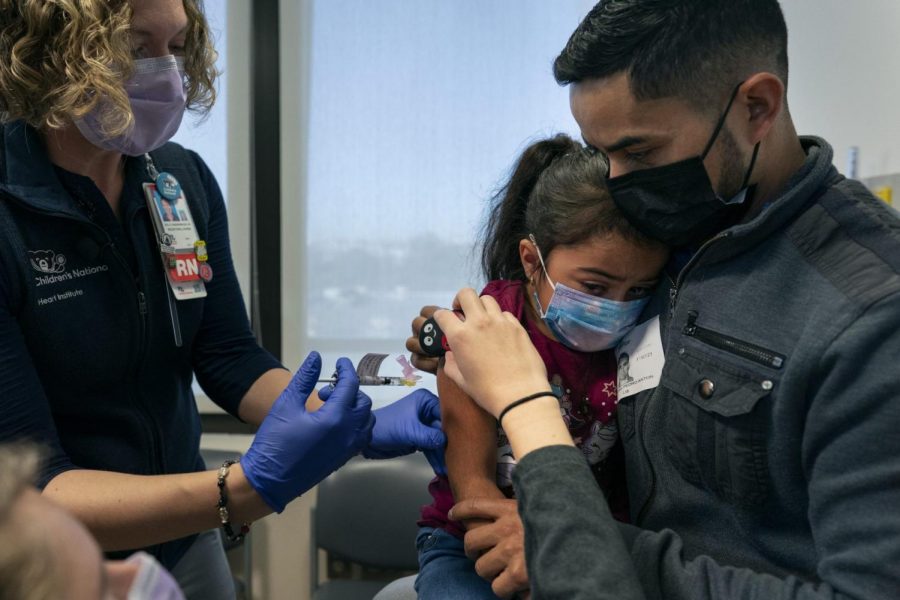 Sophia Silvaamaya, 5 años, sostenida por su padre Pedro Silvaamaya, es vacunada por la enfermera Kelly Vanderwende, el miércoles 3 de noviembre de 2021.