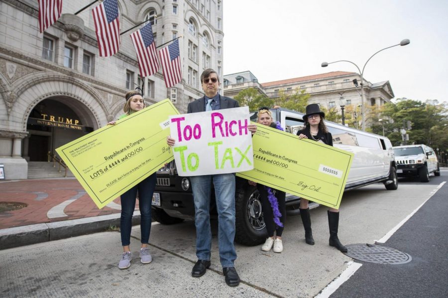 Satirical “corporations and the wealthy” protest outside the Trump Hotel, in support of higher taxes on the rich in the Build Back Better plan on Thursday, Nov. 4, 2021, in Washington. JOY ASICO | AP IMAGES FOR TAX MARCH