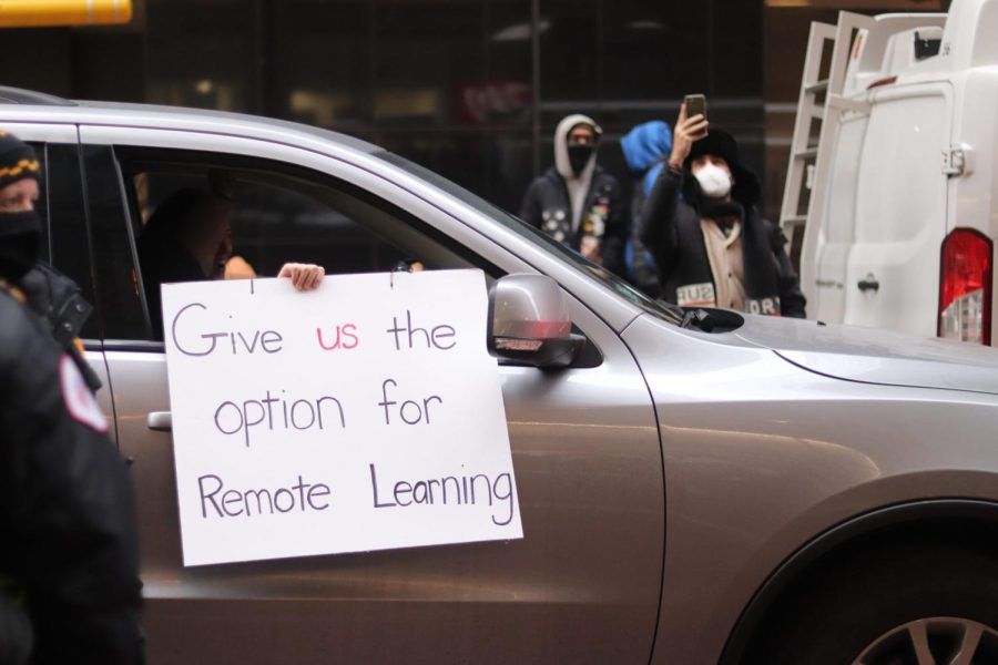 Un automóvil conduce por la sede de CPS con un letrero apoyando a los estudiantes de CPS el viernes 14 de enero.