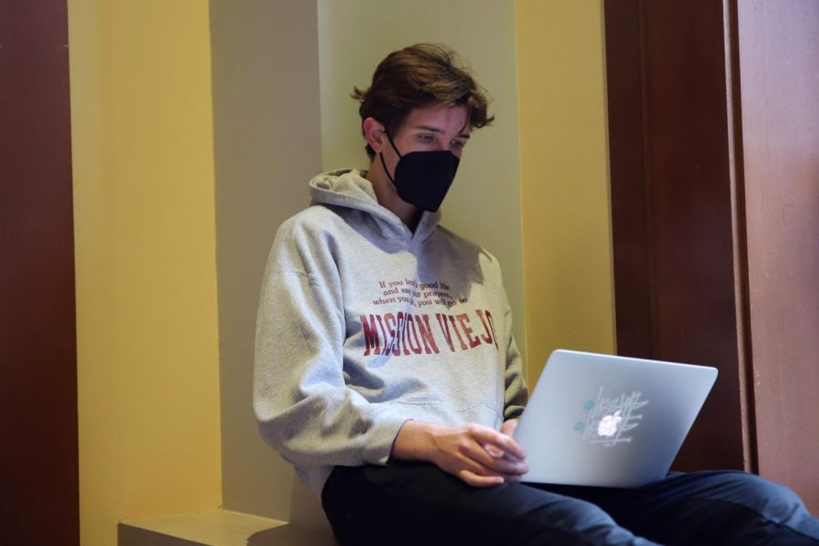 Senior Edward Conover works on some online classwork in the hallway outside of the John T. Richardson Library