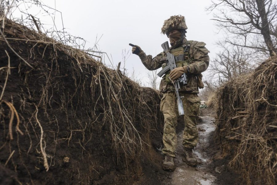 A Ukrainian soldier walks in a trench at the line of separation from pro-Russian rebels, Donetsk region, Ukraine, Monday, Jan. 10, 2022. (AP Photo/Andriy Dubchak)