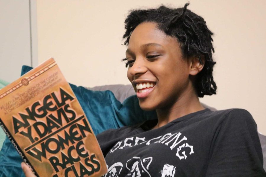 Freshman Gylani Oliver sits and reads "Women, Race and Class" by Angela Davis, who is one of Oliver's role models.