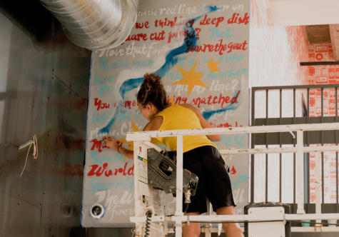 Janessa Rivera, a DePaul alumna shown working on a mural in Urbanspace. The mural highlights many elements of Chicago’s unique culture and proud art scene.