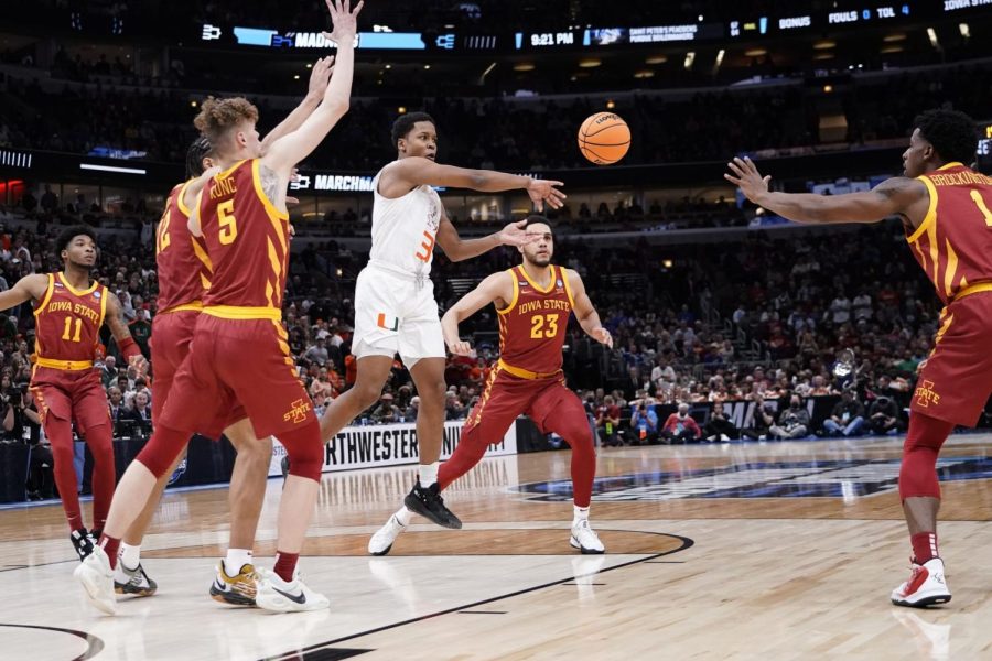 Miamis Charlie Moore passes in traffic during the first half of a college basketball game in the Sweet 16 round of the NCAA tournament Friday, March 25, 2022, in Chicago.