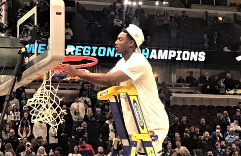 Kansas senior guard Jalen Coleman-Lands cuts down a piece of the net after defeating Miami in the Elite Eight at the United Center Sunday afternoon.