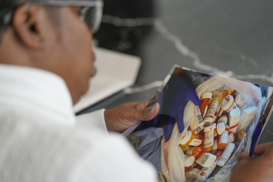 Tiffinee Scott shows some pictures to reporters, including one of the many pill bottles her daughter had accumulated before her death, after making a statement during a hearing in New York, Thursday, March 10, 2022. Scott said “After Tiarra’s passing, I collected countless pill bottles-filling a king size bed in a bag.” (AP Photo/Seth Wenig)