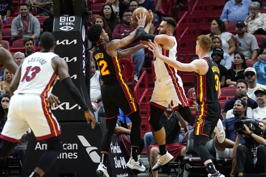 Miami Heat guard Max Strus, center right, looks to pass the ball as Atlanta Hawks forward DeAndre Hunter (12) and guard Kevin Huerter (3) defend during the first half of an NBA basketball game Friday, April 8, 2022, in Miami. (AP Photo/Lynne Sladky)