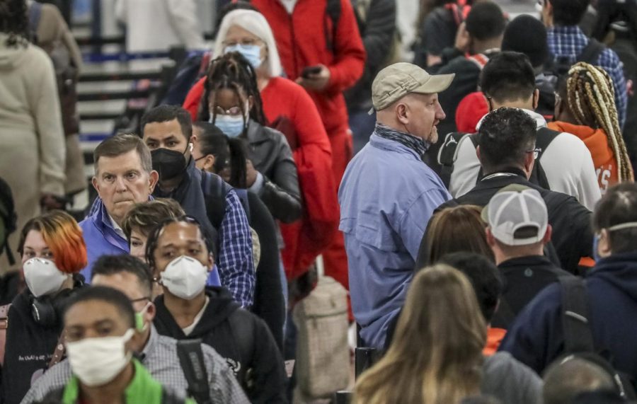 Crowds of the masked and the unmasked went through the security line at Hartsfield-Jackson International Airport on Tuesday, April 19, 2022 where the airport issued a statement Tuesday morning saying masks are now optional for employees, passengers, and visitors at the airport. Although a mask mandate will no longer be enforced, employees, passengers, and visitors are reminded that masks continue to offer a level of protection against the COVID virus, the airport said. (John Spink/Atlanta Journal-Constitution via AP)