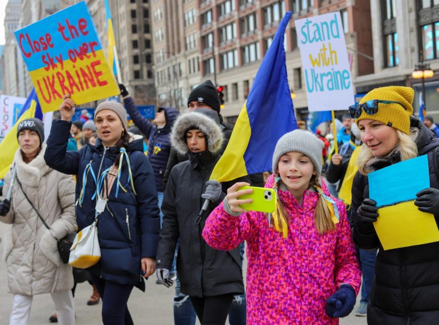 On Sunday afternoon, protestors march along Michigan Avenue carrying signs and Ukrainian flags. Many chant, Close the skies!