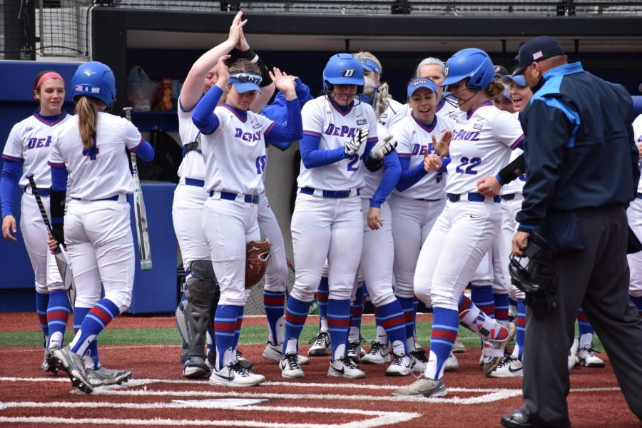  The team cheers as Anna Wohlers crosses home plate after a home run against St. Johns on April 15.