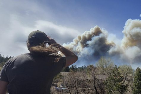 Smoke from a wind-whipped wildfire rises above neighborhoods on the outskirts of Flagstaff, Arizona, on Tuesday, April 19, 2022. (Sean Golightly, Arizona Daily Sun via AP)