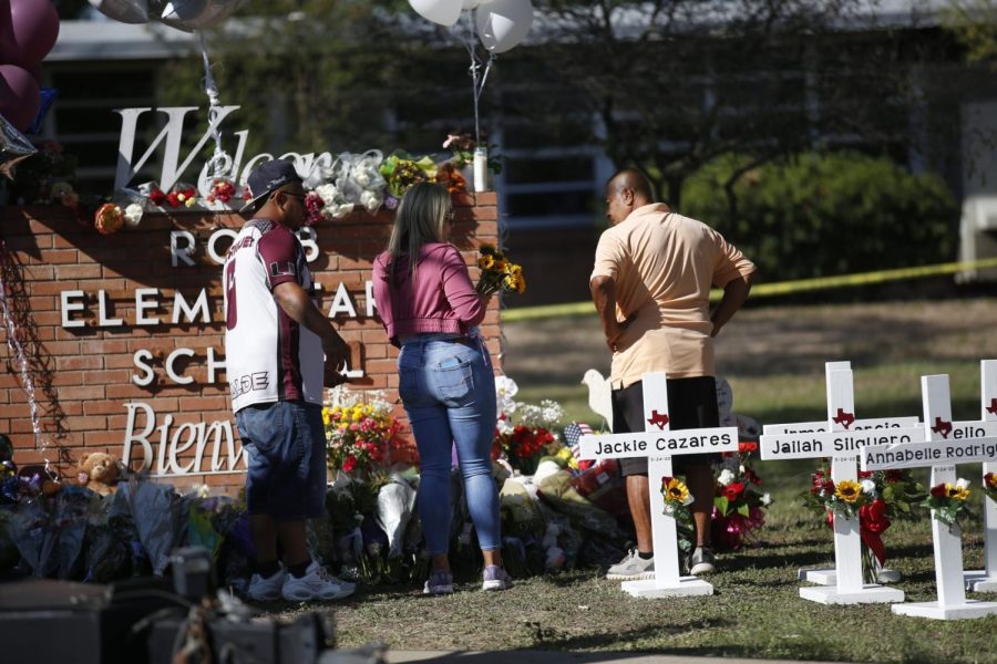 People pay their respect at a memorial set up outside of the Robb Elementary School in Uvalde, Texas Thursday, May 26, 2022. Law enforcement authorities faced questions and criticism Thursday over how much time elapsed before they stormed the Texas elementary school classroom and put a stop to the rampage by a gunman who killed 19 children and two teachers. (AP Photo/Dario Lopez-Mills)