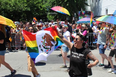 La gente del desfile sostiene una bandera del orgullo mexicano.