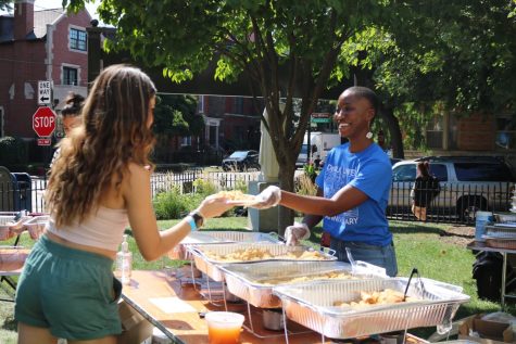 Ava Francis, the new Black Cultural Center (BCC) coordinator, hands a student a plate of food at an event for the Office of Multicultural Student Success (OMSS).