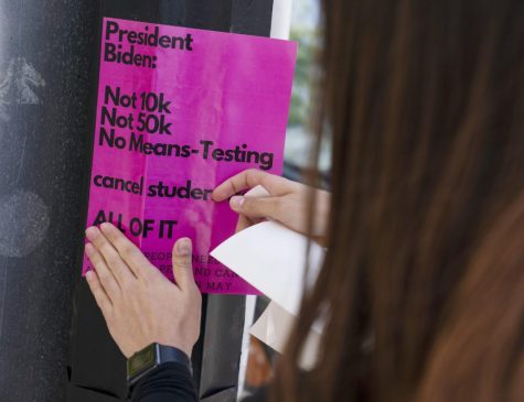 American University student Magnolia Mead puts up posters near the White House promoting student loan debt forgiveness in Washington D.C.