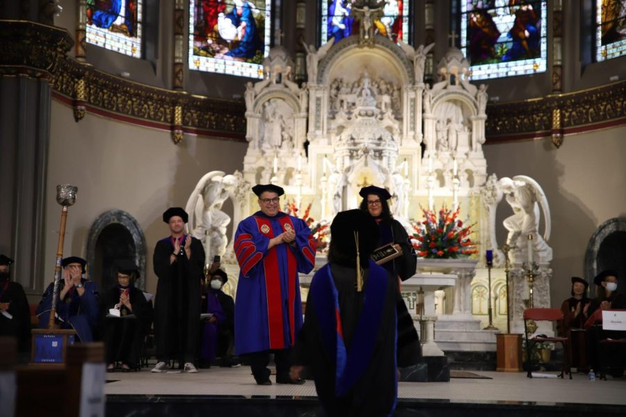 President Rob Manuel applauds a faculty member as they approach the front of the St. Vincent de Paul Parish church to be honored at the academic convocation on Sept. 1.