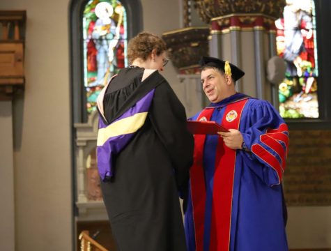 DePaul President Rob Manuel hands an award to a faculty member at the academic convocation on Sept. 1.
