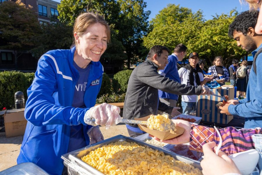 Joyana Dvorak serves a bowl of macaroni and cheese and a smile to students at Vinny Fest, September 30, 2022.