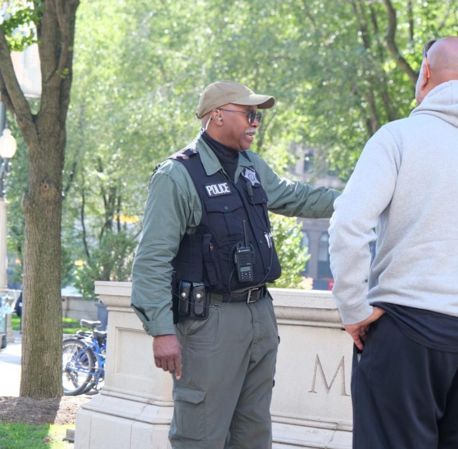 A police officer in Millennium Park speaks with park visitors. The Chicago Police Department (CPD) has already transitioned six of their nine radio zones to being digitally encrypted.