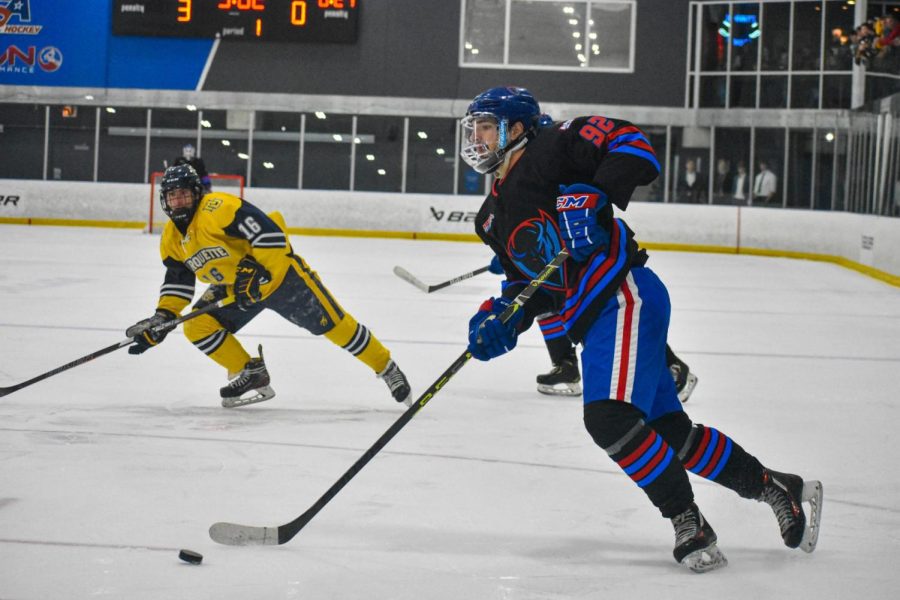 DePaul graduate student winger Brock Ash skates past defenders while setting up an assist during Friday night’s 7-1 victory against Marquette at Johnny’s Icehouse West.