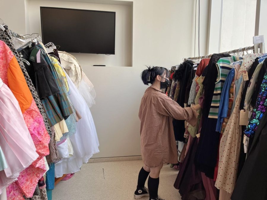 Student Tatiana Goodman looks at the racks of dresses. The Theatre School is selling old costumes from previous productions.