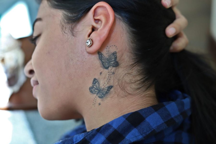 DePaul student leilani Roman shows off her only tattoo: a collection of detailed stars and butterflies located on the side of her neck.