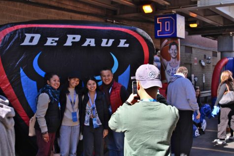 A family poses against a DePaul inflatable. Students invited their families to campus on Sat. Oct. 15 for different activities, as festivities were held on campus and around the city.
