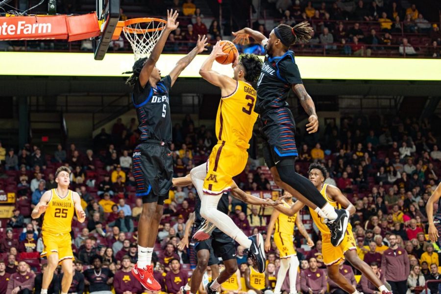Senior guard Philmon Gebrewhit (left) and junior forward DeSean Nelson (right) defend a shot attempt by Minnesota sophomore forward Dawson Garcia in DePauls win over the Gophers on Monday.