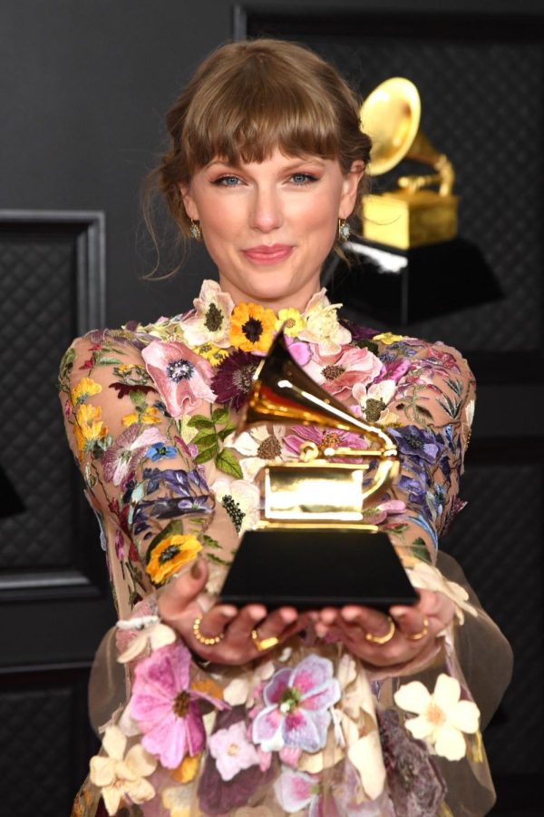 Taylor Swift brandishes her Emmy for album of the year, which she won for Folklore.