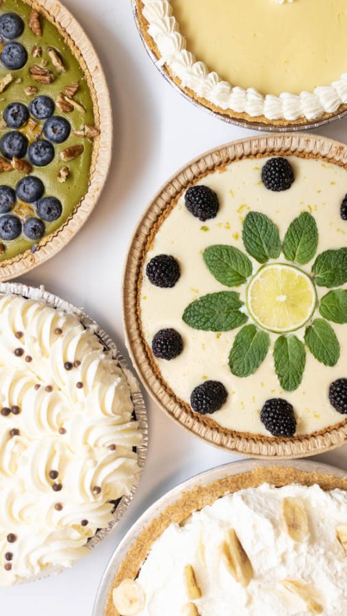 A collection of pies are displayed together from multiple pie shops and bakeries like Honey Pie bake shop, Sweet Mandy Bs, and Saritas Pleasure pie shop.