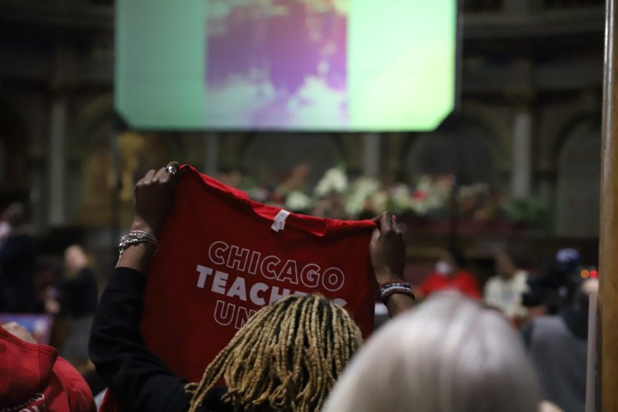 An attendee holds up a Chicago Teachers Union shirt during the mayoral forum.