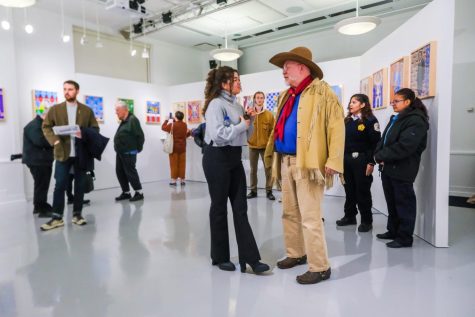 Jessica Freeman chats with Brother Mark Elder at the Richardson Art Gallery in the Lincoln Park Library. Elder has been with DePaul for 28 years and his work can be seen all over campus.