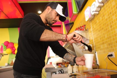 Unos de los dueños, Angelo Villagomez prepara un vaso de elote con Hot Cheetos.