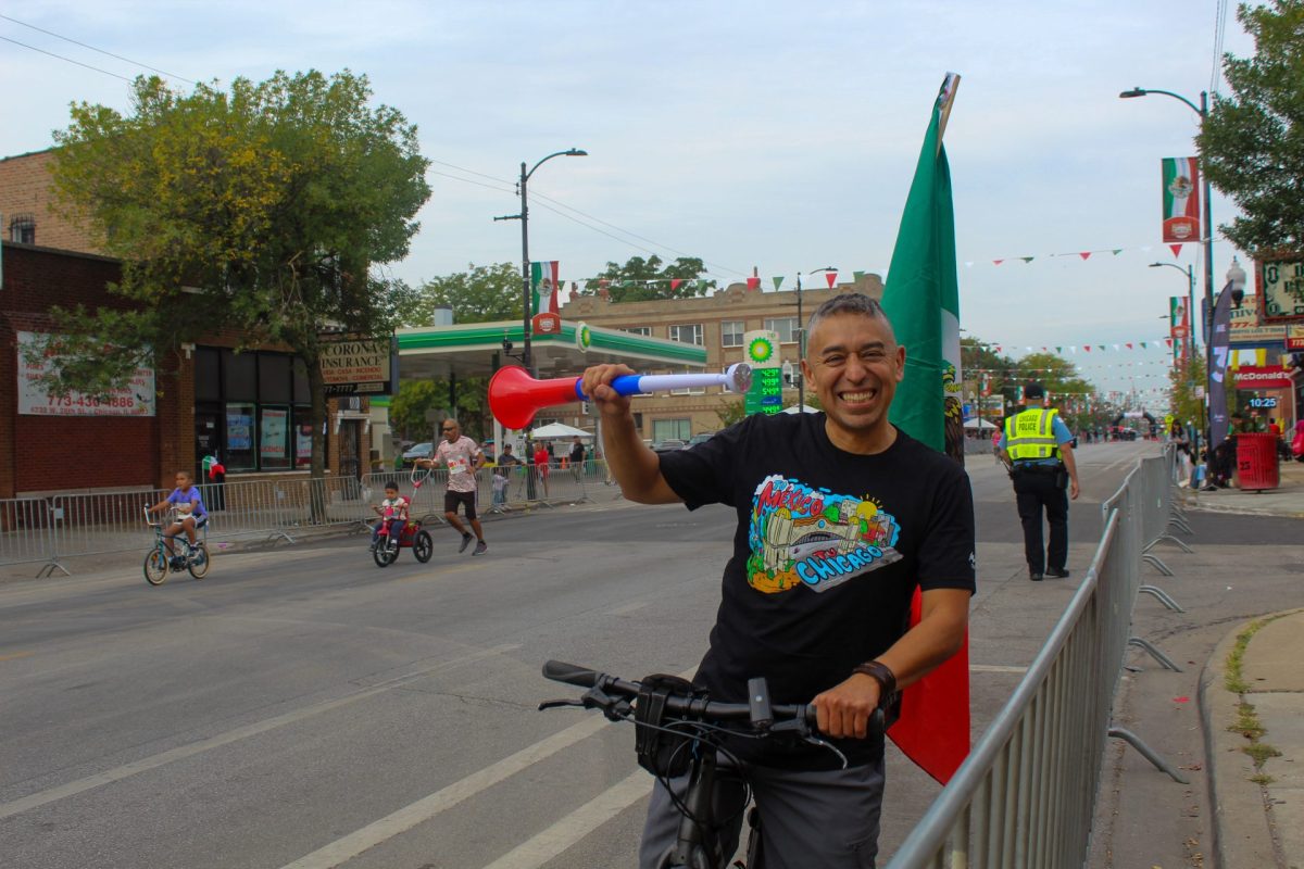 Paco Amador levanta la trompa que usa para animar a los corredores en la carrera El Grito el 16 de Septiembre.